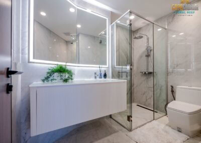 Luxusná kúpeľňa s moderným sprchovacím kútom a veľkým zrkadlom, elegantný interiér.
