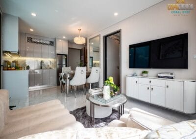 Elegant modern living room with white furniture, TV, and cozy decor in Siamiq, Thailand.