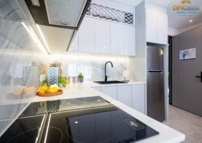 Moderná kuchyňa s bielymi skriňami a varnou doskou v apartmáne SIAMIQ, Thajsko.