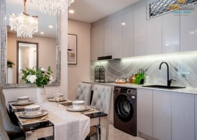 Elegant modern kitchen and dining area with white cabinetry and stylish decor.
