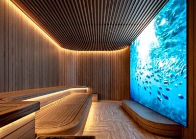 Relaxačná miestnosť s veľkým akváriom a moderným dreveným interiérom, wellness a sauna.