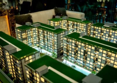 Model bytového komplexu SIAMIQ s osvetlenými oknami a zelenými strechami.