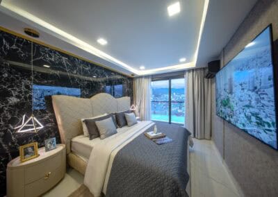 Luxusná spálňa v apartmáne SIAMIQ s výhľadom na mesto a moderným interiérom.