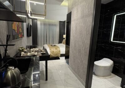 Modern hotel room with stylish decor and a separate bathroom with toilet.