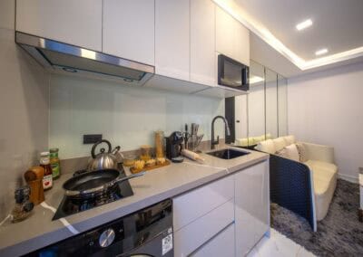 Modern kuchyň s bielymi skriňami a vybavením v apartmáne SIAMIQ.