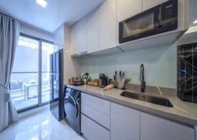 Modern kuchyňa s práčkou a balkónom v apartmáne SIAMIQ, Thajsko.