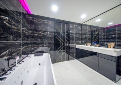 Luxusná kúpeľňa s čiernymi mramorovými obkladmi a vírivkou.