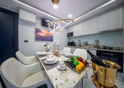 Modern kuchyň s jedálenským stolom a elegantným osvetlením v apartmáne SIAMIQ.